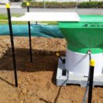 Portable rainfall activated dosing system for decanting earth bunds and sediment retention ponds.